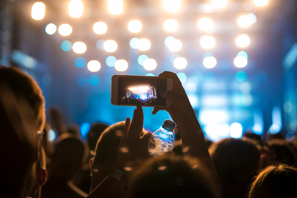 woman-crowd-taking-picture-stage-music-festival